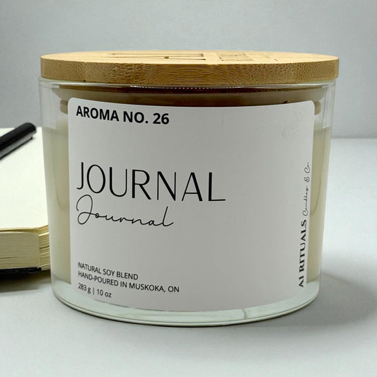 Candle with a wooden lid labeled 'Aroma No. 26 Journal' on a white background