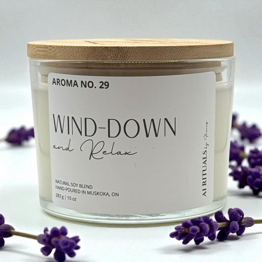 Candle labeled 'Wind Down and Relax' with lavender flowers on a light background